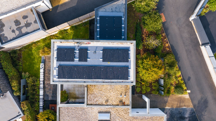 Vue aérienne d’une maison équipée de panneaux solaires et solution énergétique H2Gremm